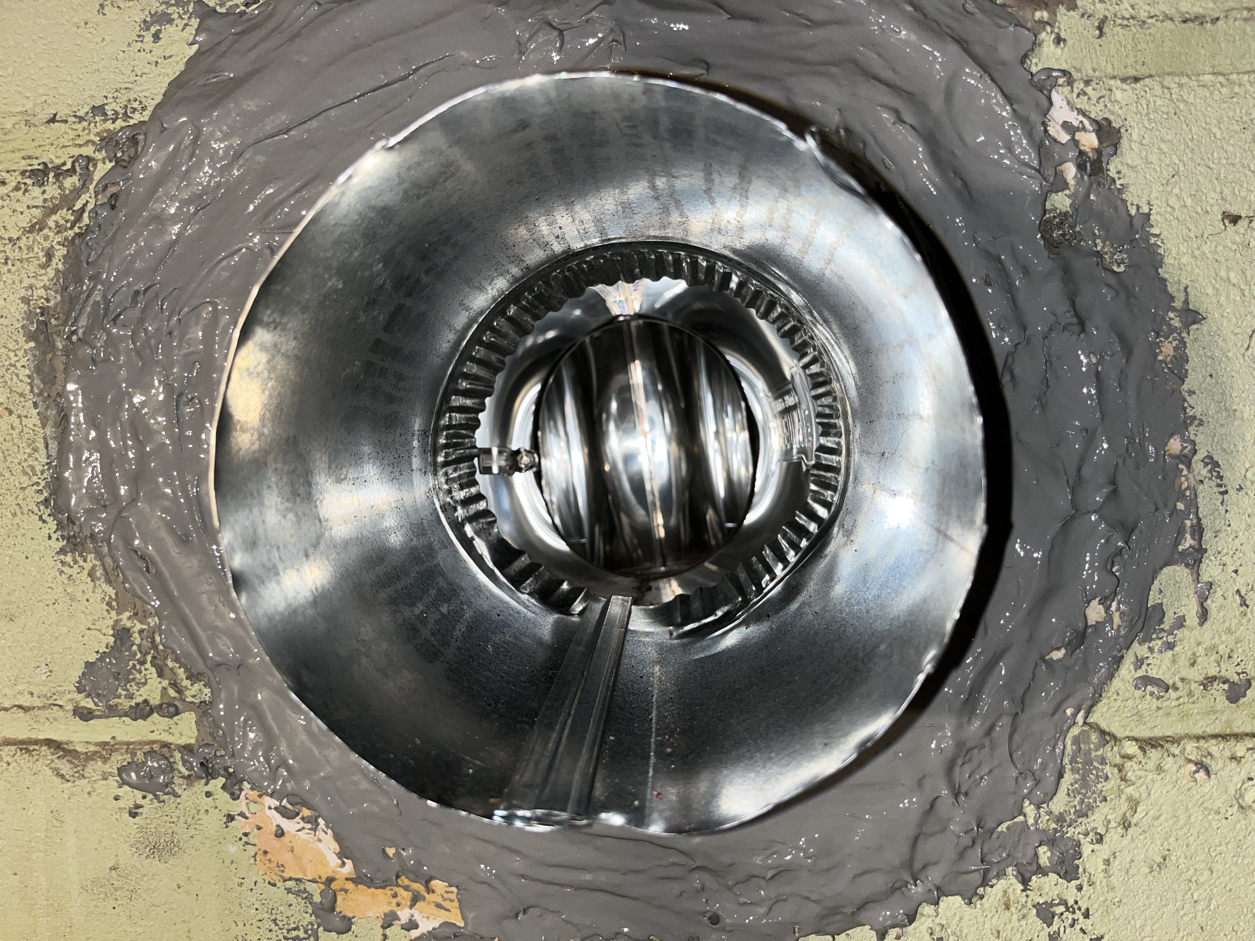 Top-down view of new stainless steel liner installed with fresh cement seal